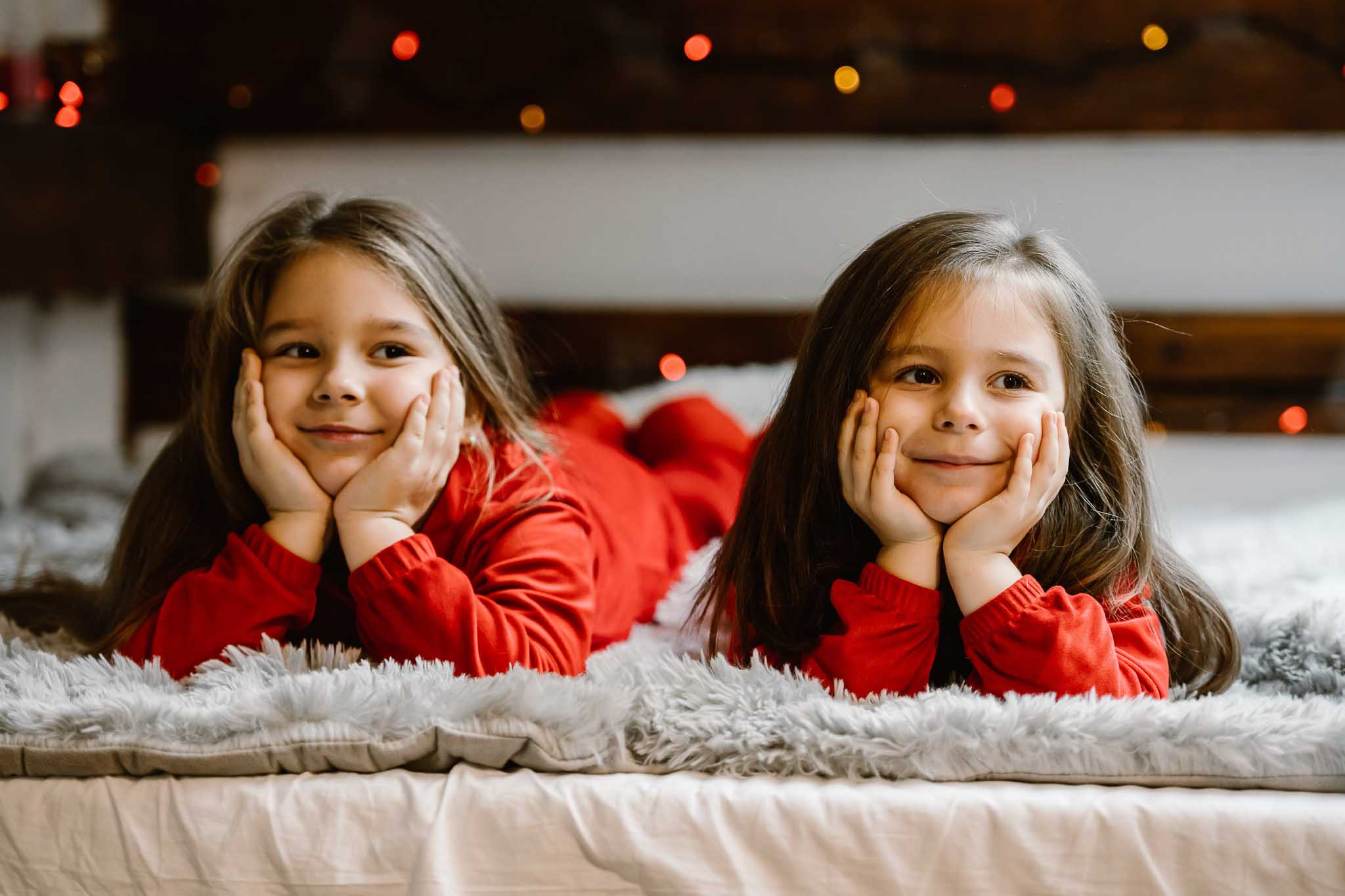 Familie de Crăciun fotografiată printre ramurile bradului, cu toți îmbrăcați în roșu