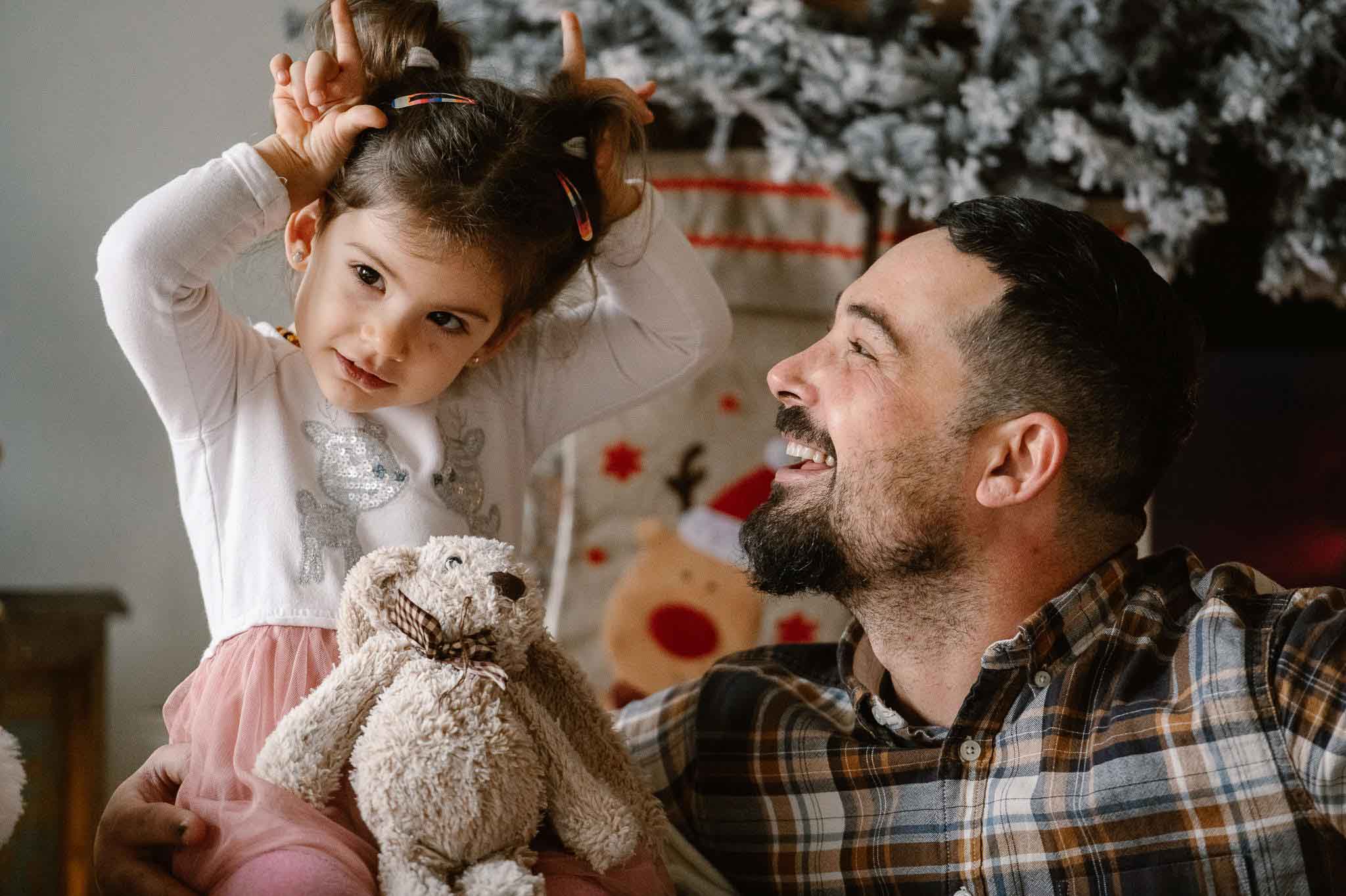Portret de Crăciun cu fetiță în costumaș roșu lângă brad