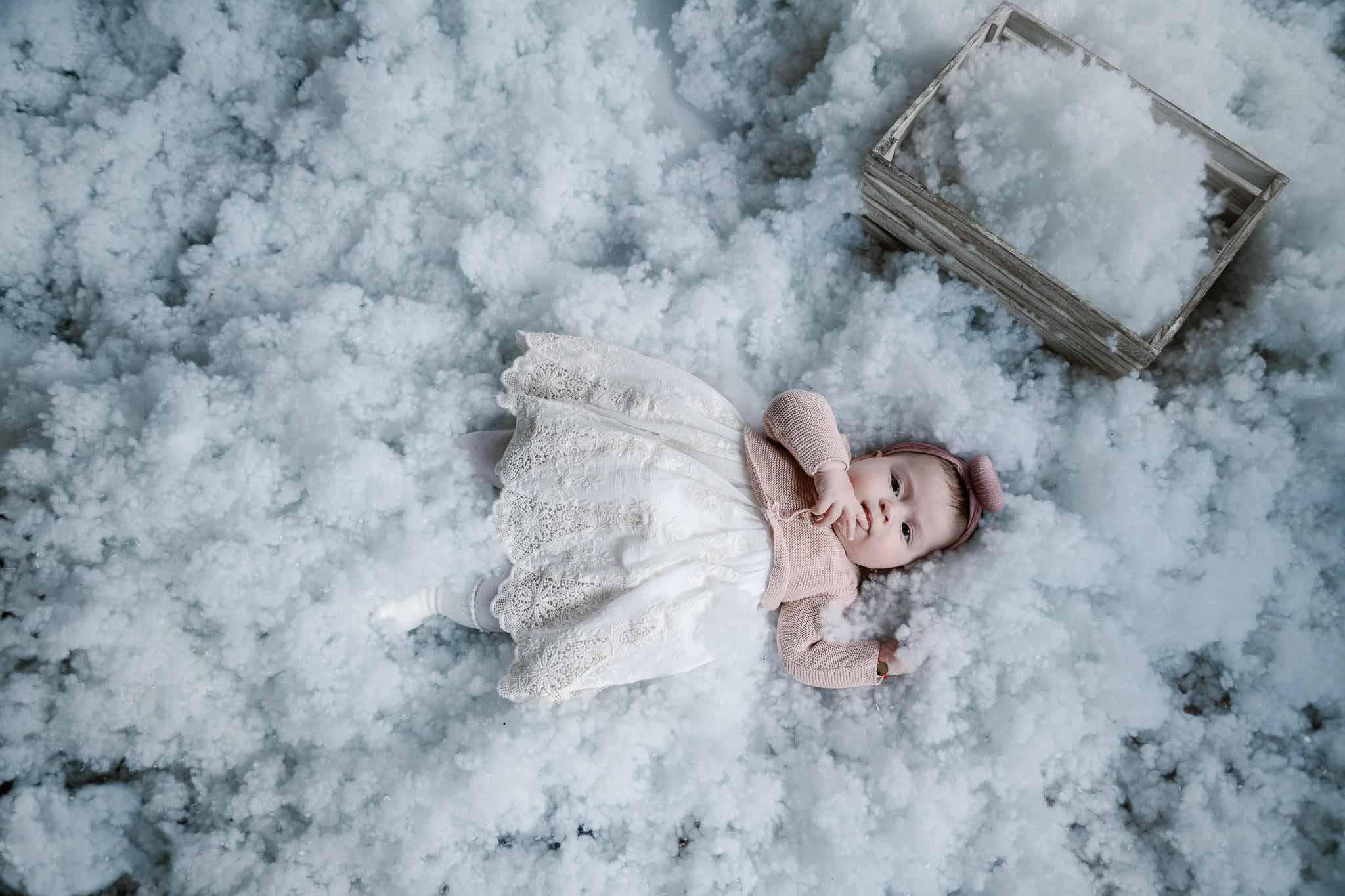 Mamă și fiică râzând în timp ce câinele familiei o linge pe cea mică